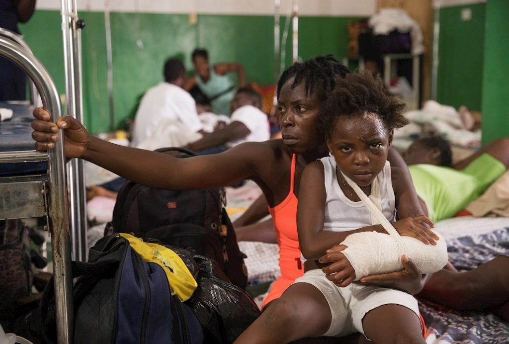 Daline Noel carga a su hija Bernard Lenise, quien permanece recluida hoy en el hospital general Immaculée Conception, luego del terremoto del pasado 14 de agosto, en Les Cayes (Haití). EFE/ Orlando Barría