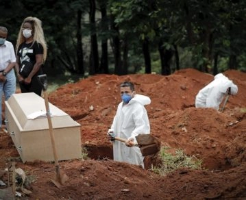 Un trabajador entierra a una víctima de covid-19, mientras familiares se lamentan en el Cementerio Vila Formosa, en Sao Paulo (Brasil). EFE/Fernando Bizerra Jr/Archivo
