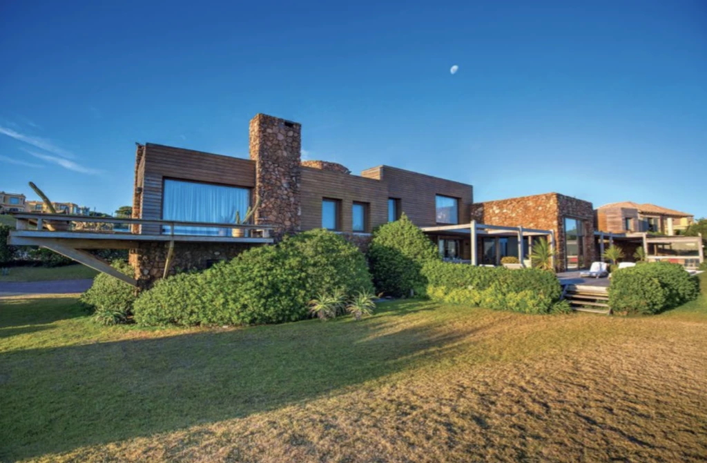 La fachada revestida en piedra, a metros de la arena.