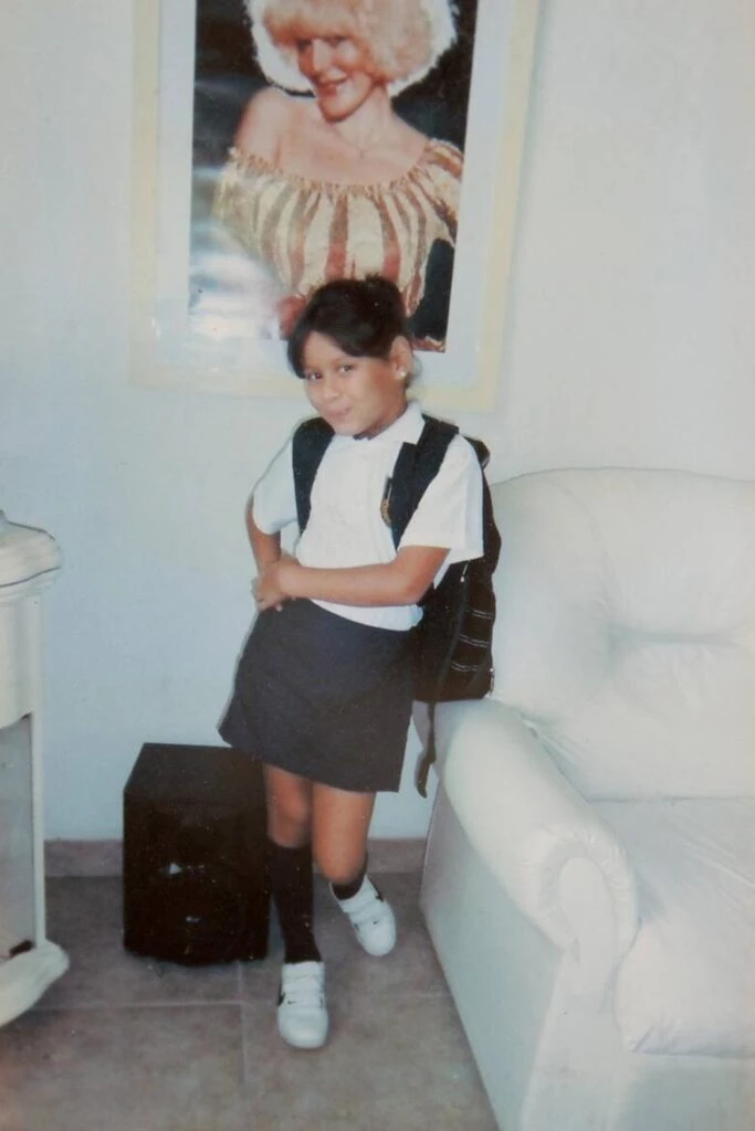 Verónica posa frente a un cuadro con la figura de su mamá en el primer día de escuela. 