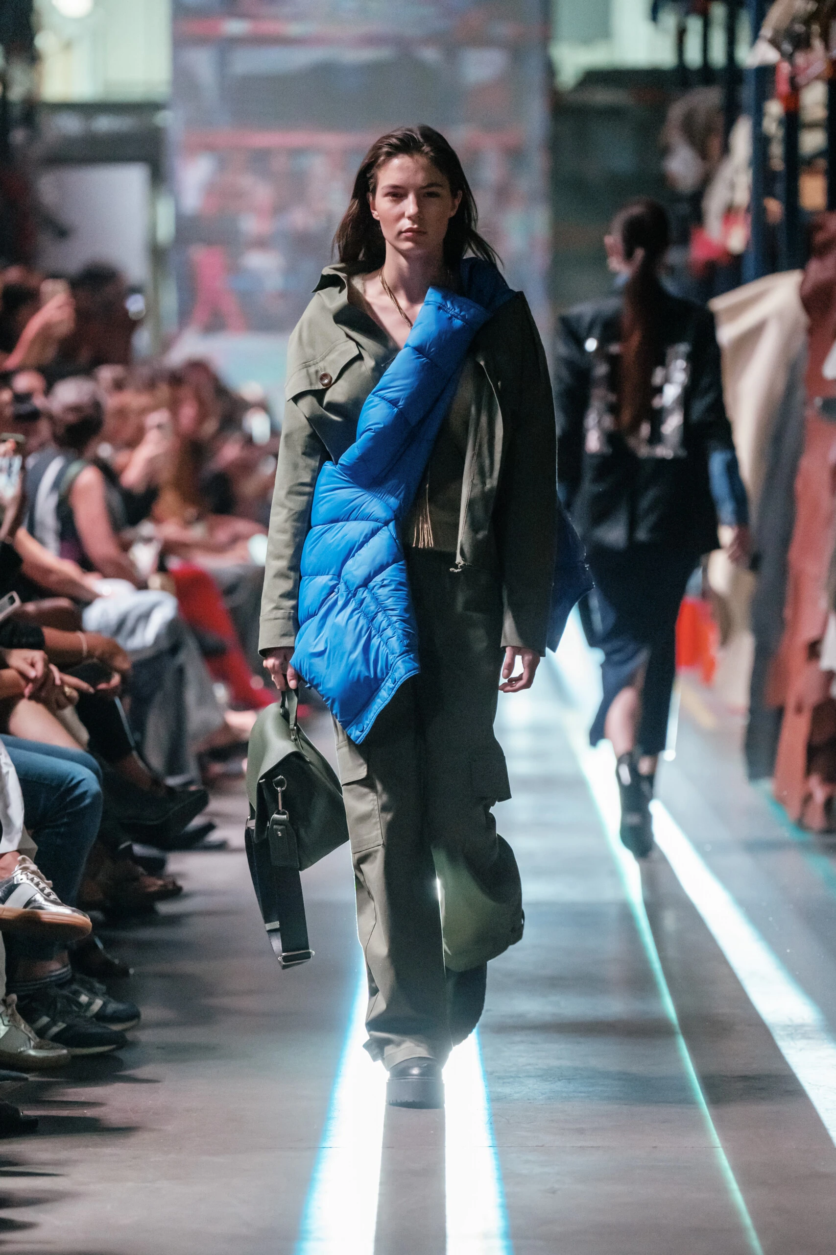 El look con el que desfiló Helena Otamendi está compuesto por un conjunto con unos jeans y unas botas con una campera azul eléctrica muy canchera y una cartera.