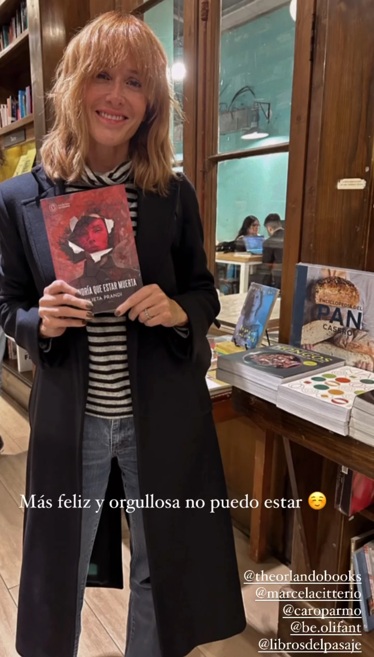 Si de infaltables se habla, Julieta Prandi se mostró orgullosa con su libro con un tapado largo de corte clásico en color azul noche. 