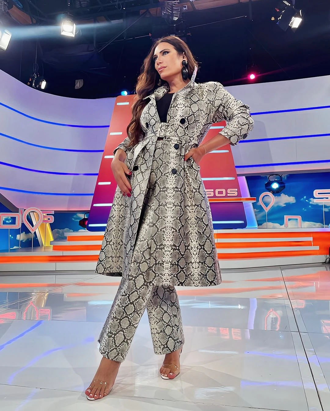 Flor de la V condujo Intrusos con un trench y pantalón con diseño snake de la firma Iman con sandalias transparentes