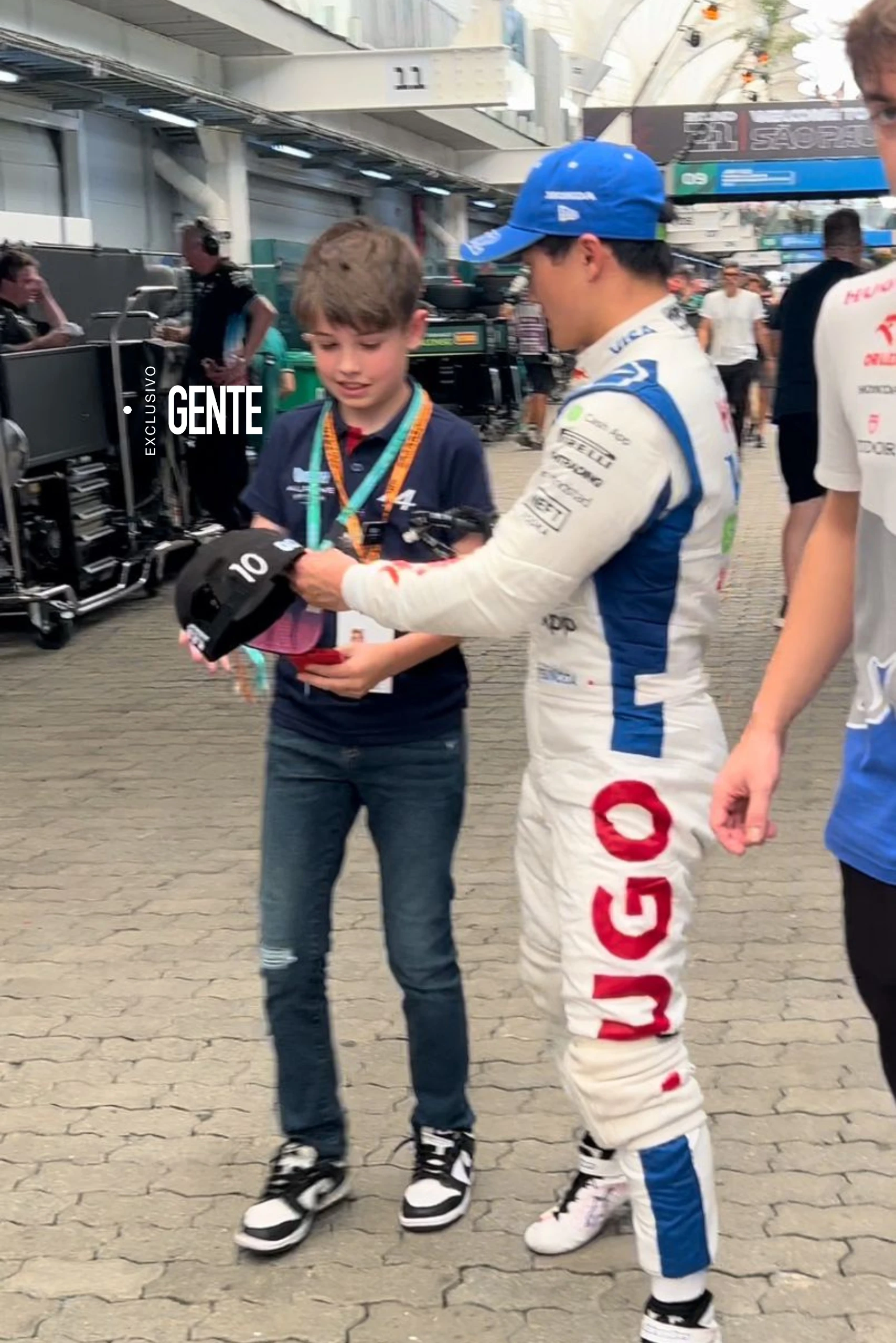 Un fan aprovecha para pedirle a Tuki Tsunoda que le firme su gorra.