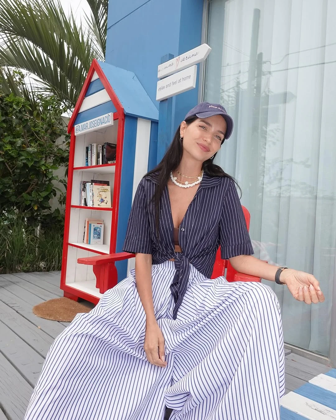 total look oversize compuesto por una camisa azul con rayas blancas que usó anudada en la parte frontal y pantalón del mismo diseño, de base blanca con franjas azules con piernas anchas, tiro alto y tablas delanteras y frontales.