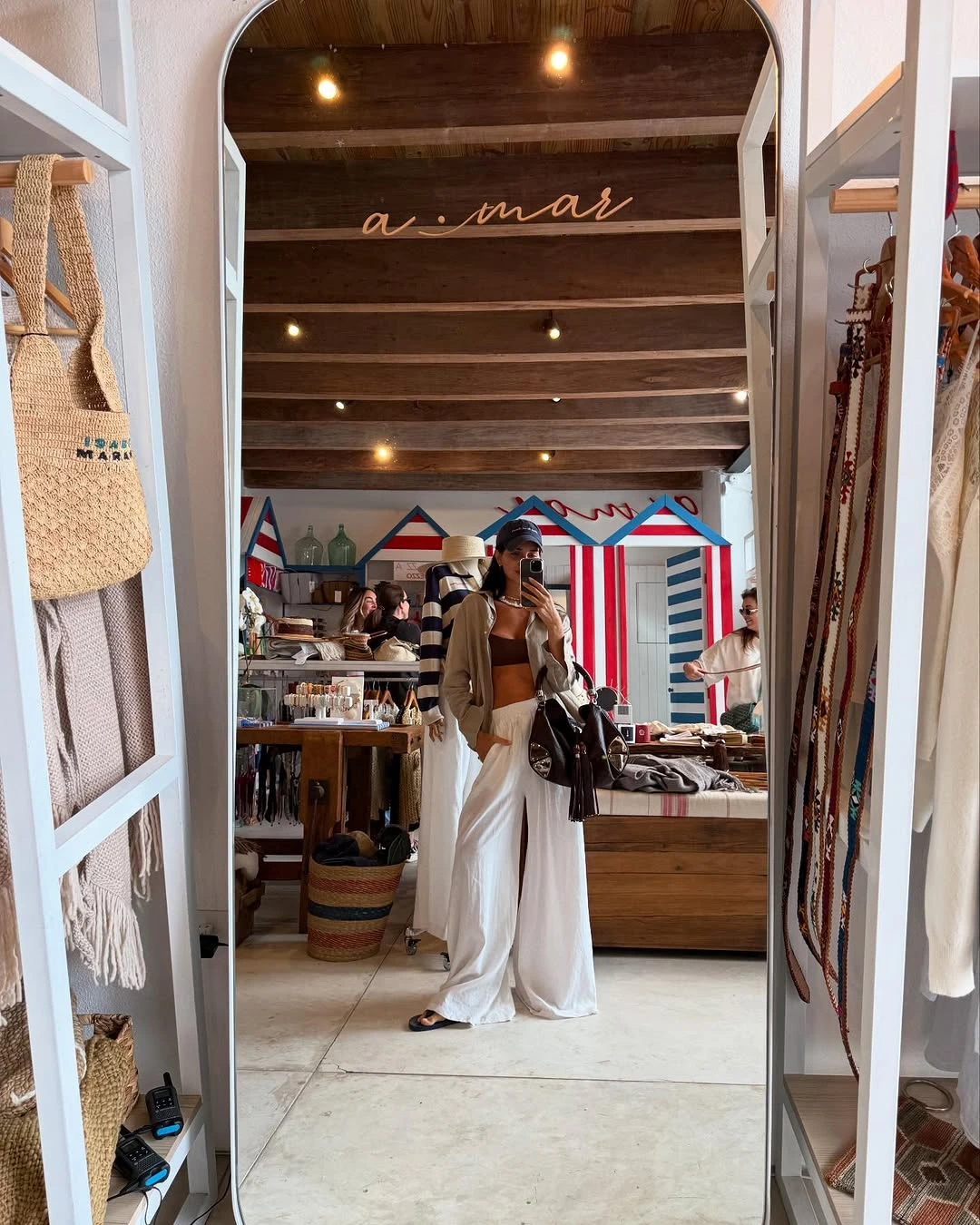 pantalón de lino blanco de estilo oversize, que combinó con una camisa beige y un top chocolate. Añadió un collar, gorra y ojotas de color negro.