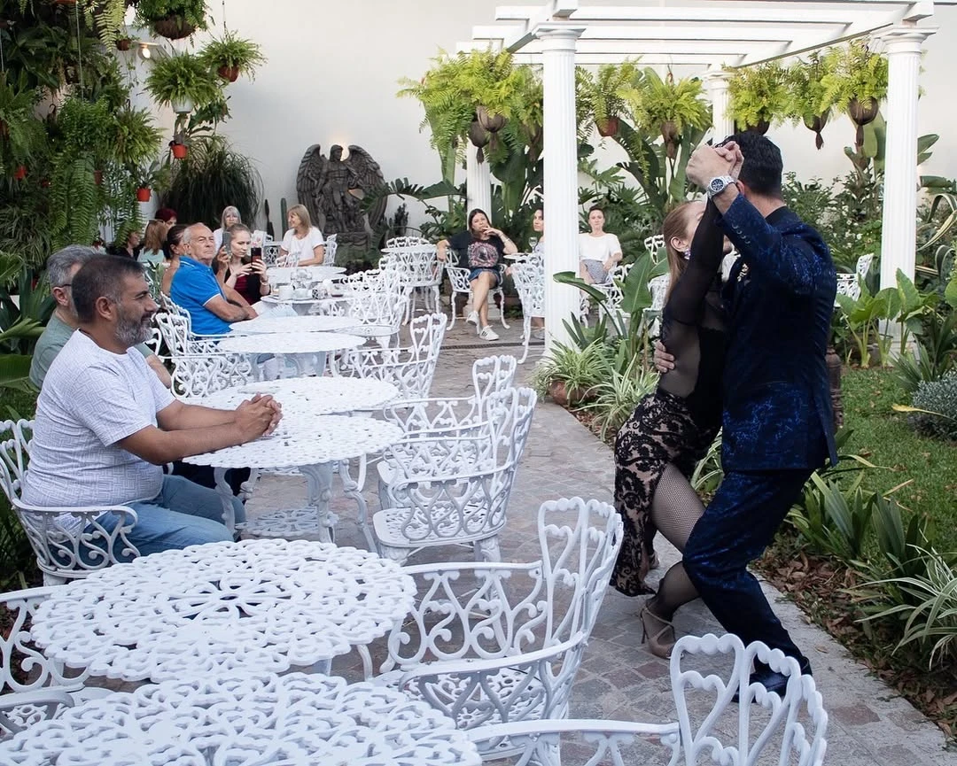 Jardín interior: Un patio central con cielorraso de vidrio permite la entrada de luz natural, creando un ambiente luminoso y aireado. Plantas en macetas de hierro forjado y detalles de hierro forjado en las barandas complementan la estética del lugar.
