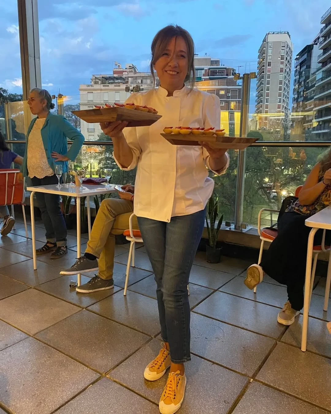 Paula Roldán, dueña del café, posa con los imponentes ventanales de fondo.