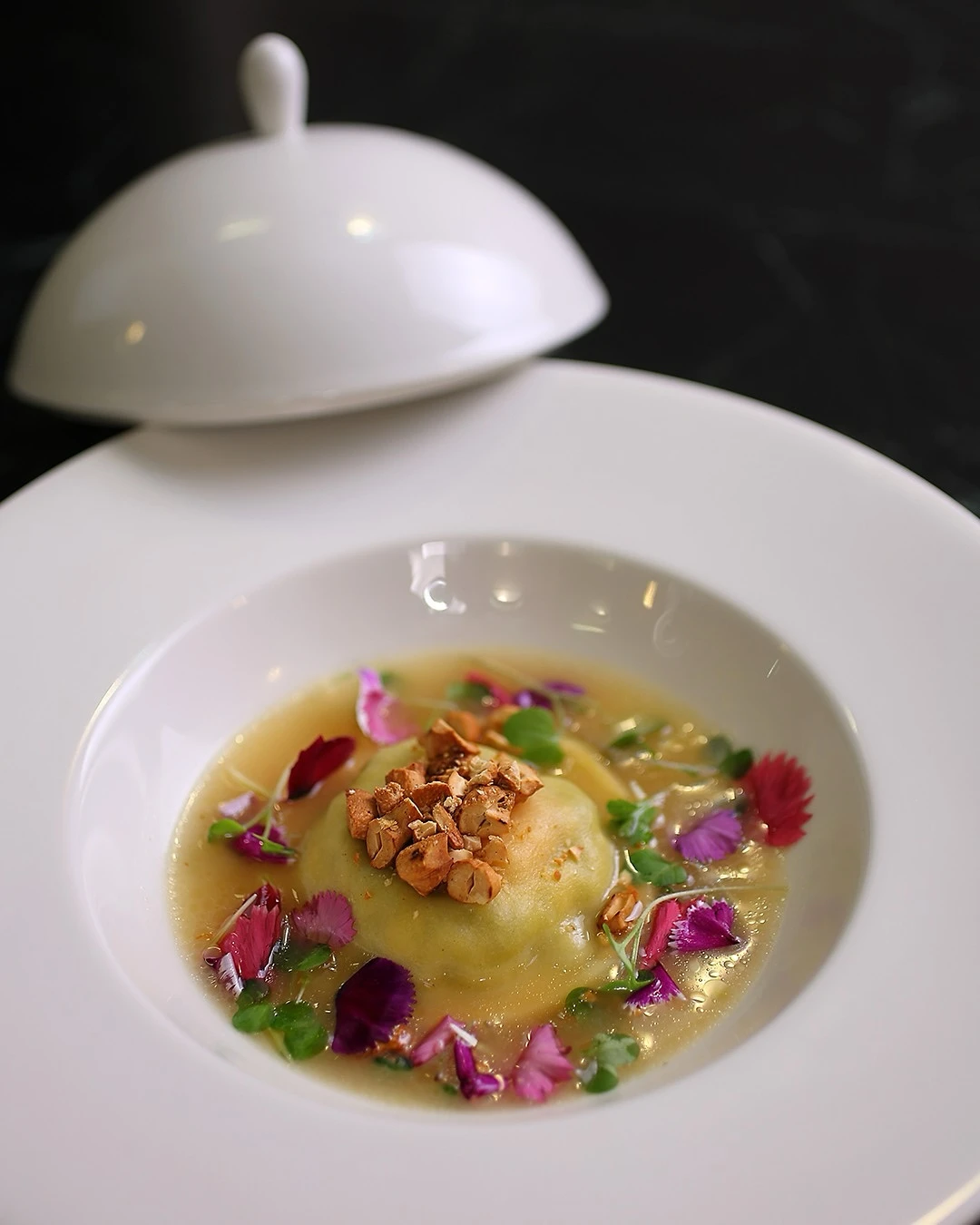 Ravioli de ricotta y espinaca en un delicado brodo de parmeggiano. 