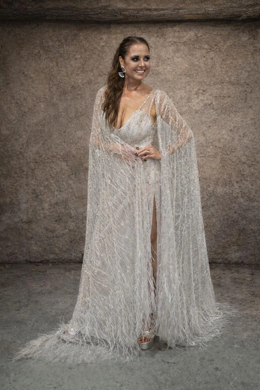 Vestido plata al cuerpo, confeccionado en tul con aplicaciones de plumas. 