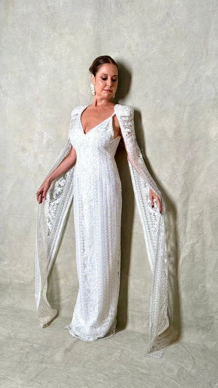 Vestido blanco de línea recta, confeccionado en encaje con delicadas guardas bordadas a mano.