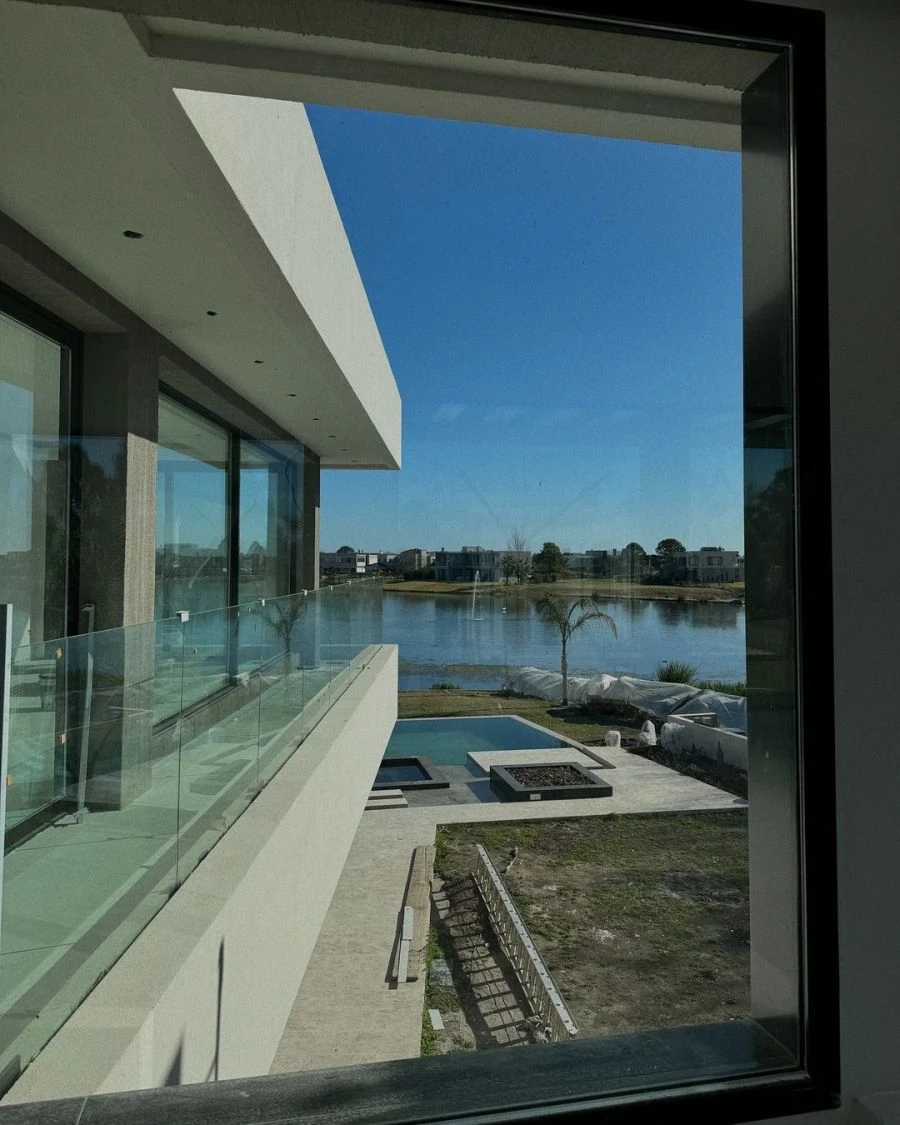El gran ventanal permite admirar con todo su esplendor el patio verde y los lagos que componen el barrio privado